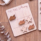 A wooden tic-tac-toe game board with wooden tiles and wooden game pieces, including a tank and a star, placed on a wooden surface.