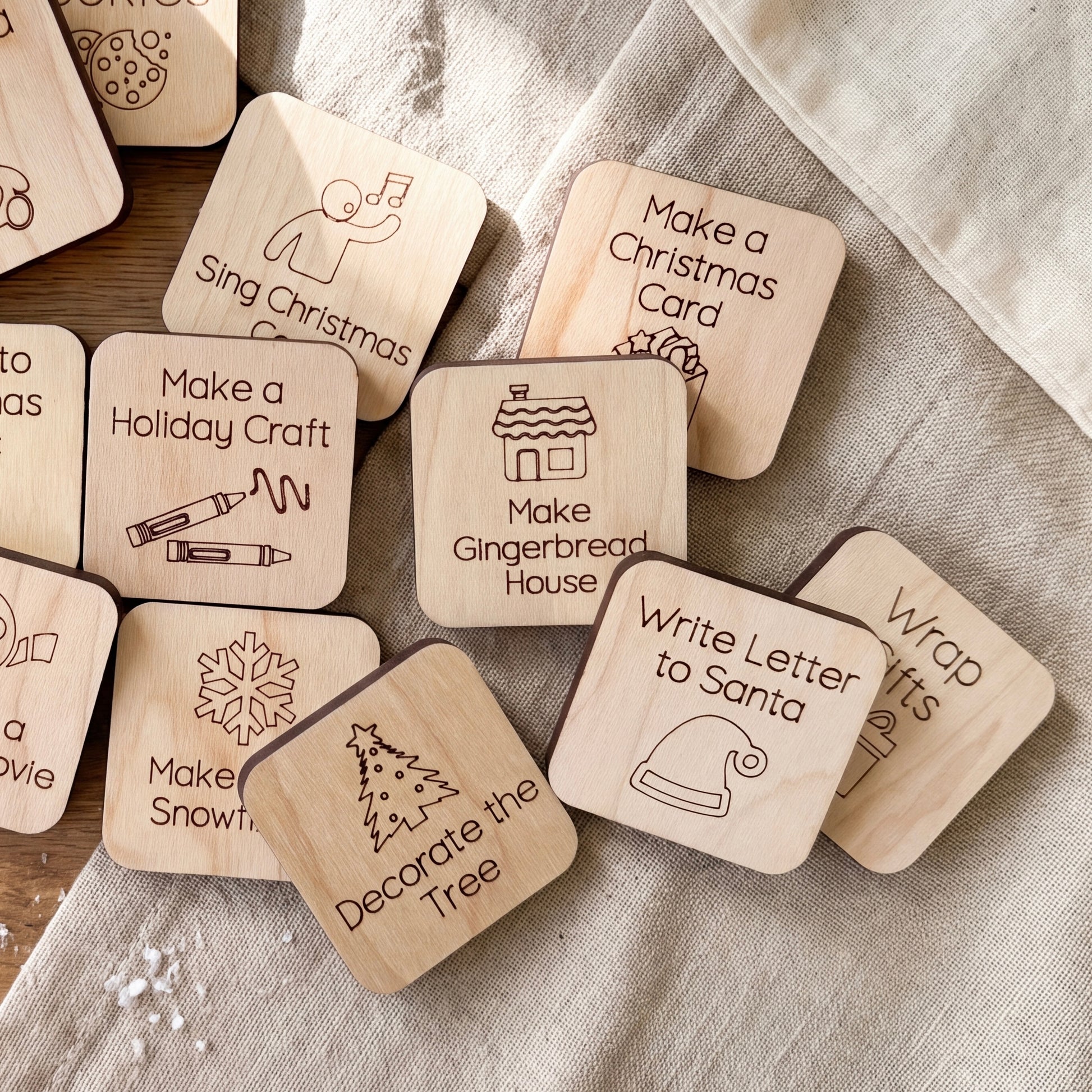 a collection of wooden coasters or magnets with various holiday-themed designs and instructions, such as "Make a Holiday Craft", "Make a Gingerbread House", "Write Letter to Santa", and "Decorate the Tree".