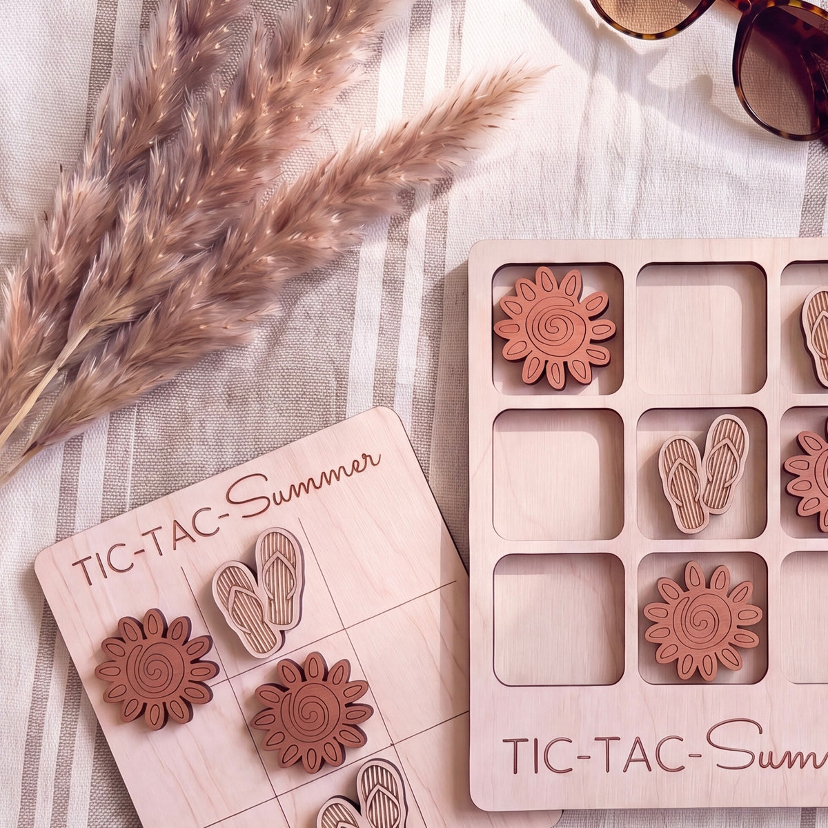 a wooden tic-tac-toe game with wooden tiles and a wooden board, along with some decorative elements such as straw and sunglasses.