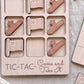 A wooden tic-tac game board with wooden pieces shaped like flags and stars, along with the text "C-TAC-Take It" printed on the board.