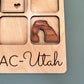a wooden magnet with a picture of a rock formation